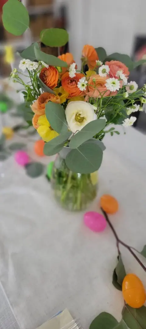 Colorful flower arrangement with decorative Easter eggs.