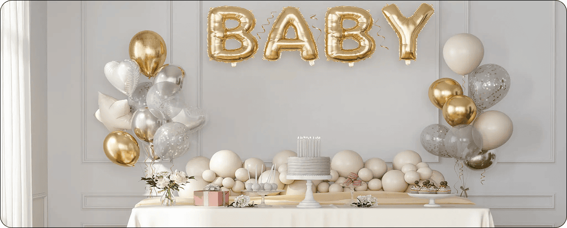 Baby-themed celebration table with gold balloons.