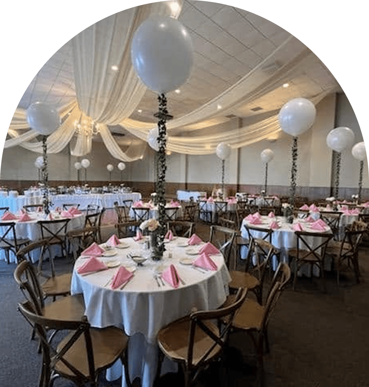Elegant dining setup with pink napkins and balloons.