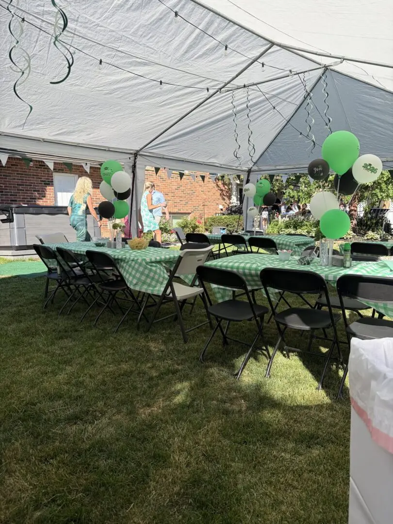 Outdoor party setup with green decorations and balloons.