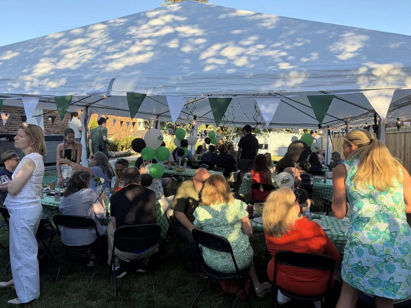 Lively outdoor gathering under a festive tent.