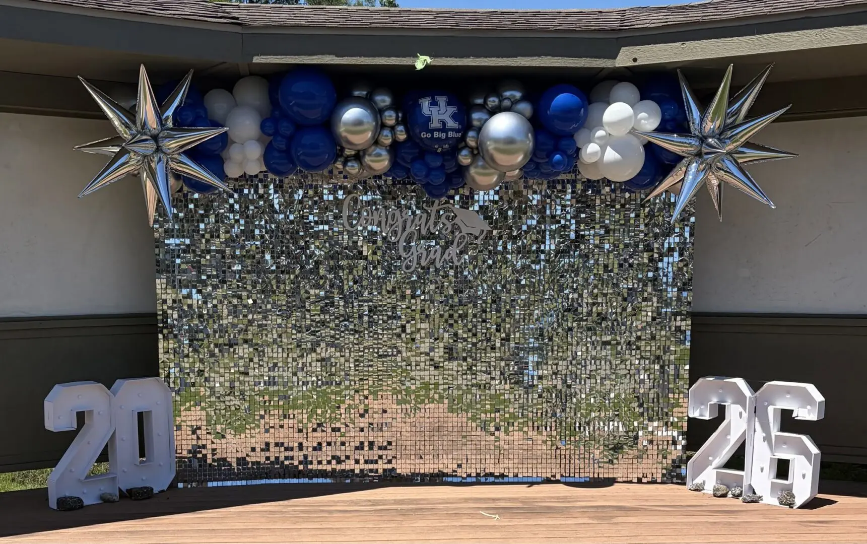Graduation backdrop with balloons and star decor.