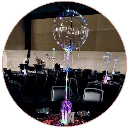 Colorful balloon centerpiece with twinkling lights.